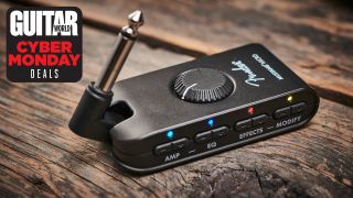 A Fender Mustang Micro headphone amp for guitar on a wooden floor