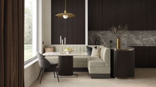 A dining nook featuring banquette seating. The banquette is upholstered in a neutral beige fabric with vertical channel tufting. It’s L-shaped, fitting neatly into the corner of the room.