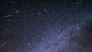 streaks of light cross the starry night sky