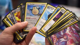 A player shuffles through a deck of Pokemon TCG cards.