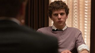 A still from the movie The Social Network, one of the new Prime Video movies, of Jesse Eisenberg, playing Mark Zuckerberg, sat in a meeting room