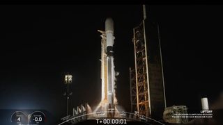 a black and white spacex falcon 9 rocket launches into a night sky