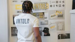 Here Design process of creating Untold identity with young male prisoners - man with untold t-shirt looking at mood board