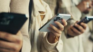 People holding iPhones in a queue