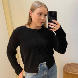 Woman wears black cashmere jumper, blue jeans