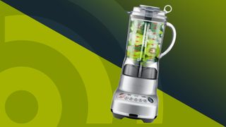 Blender containing kiwi slices, broccoli and ice on a green background