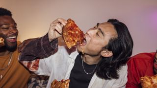 A man eats pizza