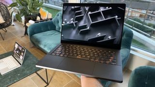 Asus ROG Zephyrus G14 (2024) being held in an apartment.