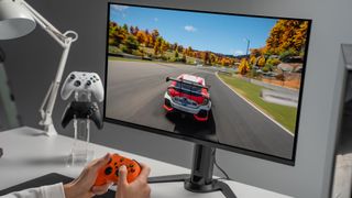 A person playing a racing game on a Gigabyte OLED Monitor