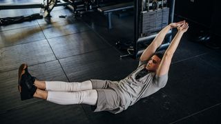 Man performing a hollow body hold core exercise