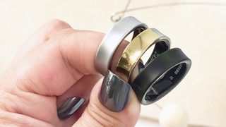 Three Samsung Galaxy Rings in a user&#039;s hand shown in silver, gold and black