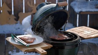 Outdoor grilling on the balcony at a cold winter day with fresh snow 