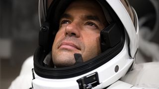 closeup of the face of a man wearing a white space helmet