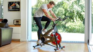 Man working out with an upright exercise bike at home