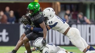 Noah Whittington #6 of the Oregon Ducks runs the ball and is tackled ahead of the College Bowls 2024-25