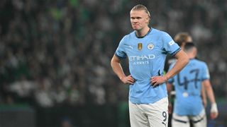 Manchester Citys Erling Haaland stands with his hands on his hips during his teams Champions League defeat to Sporting Clube de Portugal.