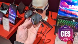 A hand holding the Lenovo Legion Glasses 2 with the Windows Central CES 2025 badge