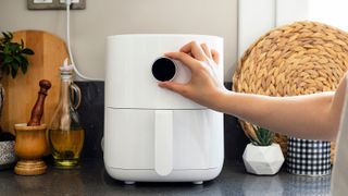 Air fryer being used by a woman