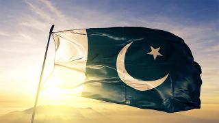 Pakistan flag flying, with sun in the background