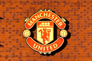 The Manchester United club crest on a brick wall outside Old Trafford