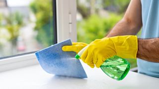 Spraying cleaner onto cloth