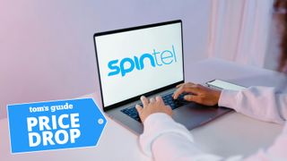 Woman using laptop with SpinTel logo on computer screen and Tom&#039;s Guide blue Price Drop badge on bottom left corner