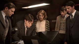 The main characters of the Imitation Game, one of the best new Max movies in January 2025, including Keira Knightley and Benedict Cumberbatch, gather around a desk