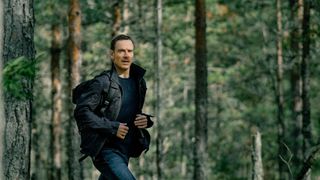 Michael Fassbender running in the woods in The Agency