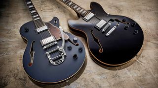 Two D&#039;Angelico guitars on a stone floor