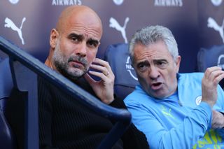 Manchester City manager Pep Guardiola and assistant manager Juanma Lillo in discussion on the bench during a Premier League match against Fulham, October 2024