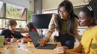 A student and teacher in a classroom with the HP Fortis G1i Chromebook.