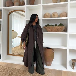 Fashion influencer @monikh wearing a brown coat in her home in London.