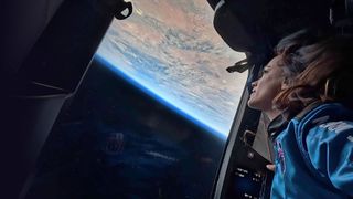 Emily Calandrelli, the 100th woman in space, looks down at Earth through a window aboard Blue Origin&#039;s New Shepard crew capsule on the NS-28 suborbital mission on Nov. 22, 2024.