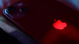 A red Apple iPhone with a glowing logo