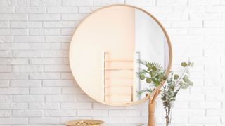 Round mirror on white wall