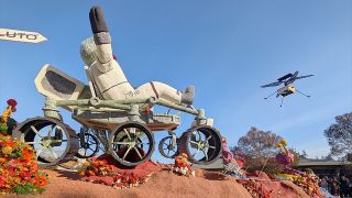 flower-covered parade float depictions of an astronaut riding a Mars rover and a flying drone