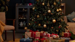 Christmas tree with gold accents and pile of presents in cozy home interior 