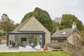 Stone clad extension to cottage with large sliding doors