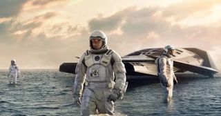 Three astronauts and their spaceship on a water-covered planet.