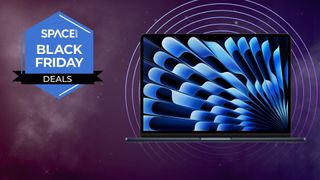 A MacBook Air M3 13-inch laptop against a starry background next to a Space Black Friday Deals logo. 