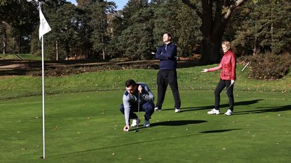 golfer taking a long time to line up a putt while two other golfers look annoyed