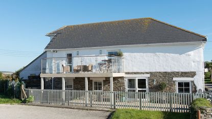 Exterior view of a converted barn, with a side extension