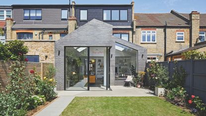 Exterior of a kitchen extension, with sliding doors to the garden, and a large picture window