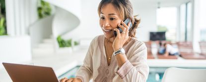 Woman on Phone Working on Laptop