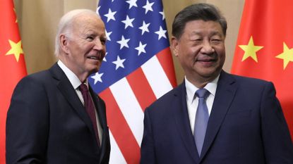 President Biden and President Xi in dark suits in front of Chinese and American flags