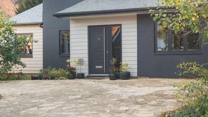 Driveway with concrete paving in front of house in the autumn