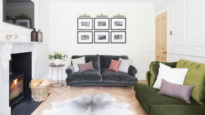 White panelled living room with wooden parquet flooring and a fluffy rug in the centre