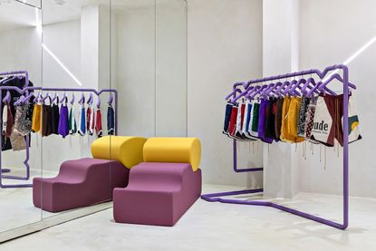 A fancifully designed flagship features purple-tinted, wavy furniture.