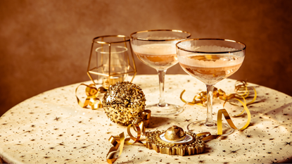 Two glasses of champagne on a table with Christmas decorations