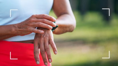 Woman checking fitness watch device on wrist after learning how to clean a Fitbit 